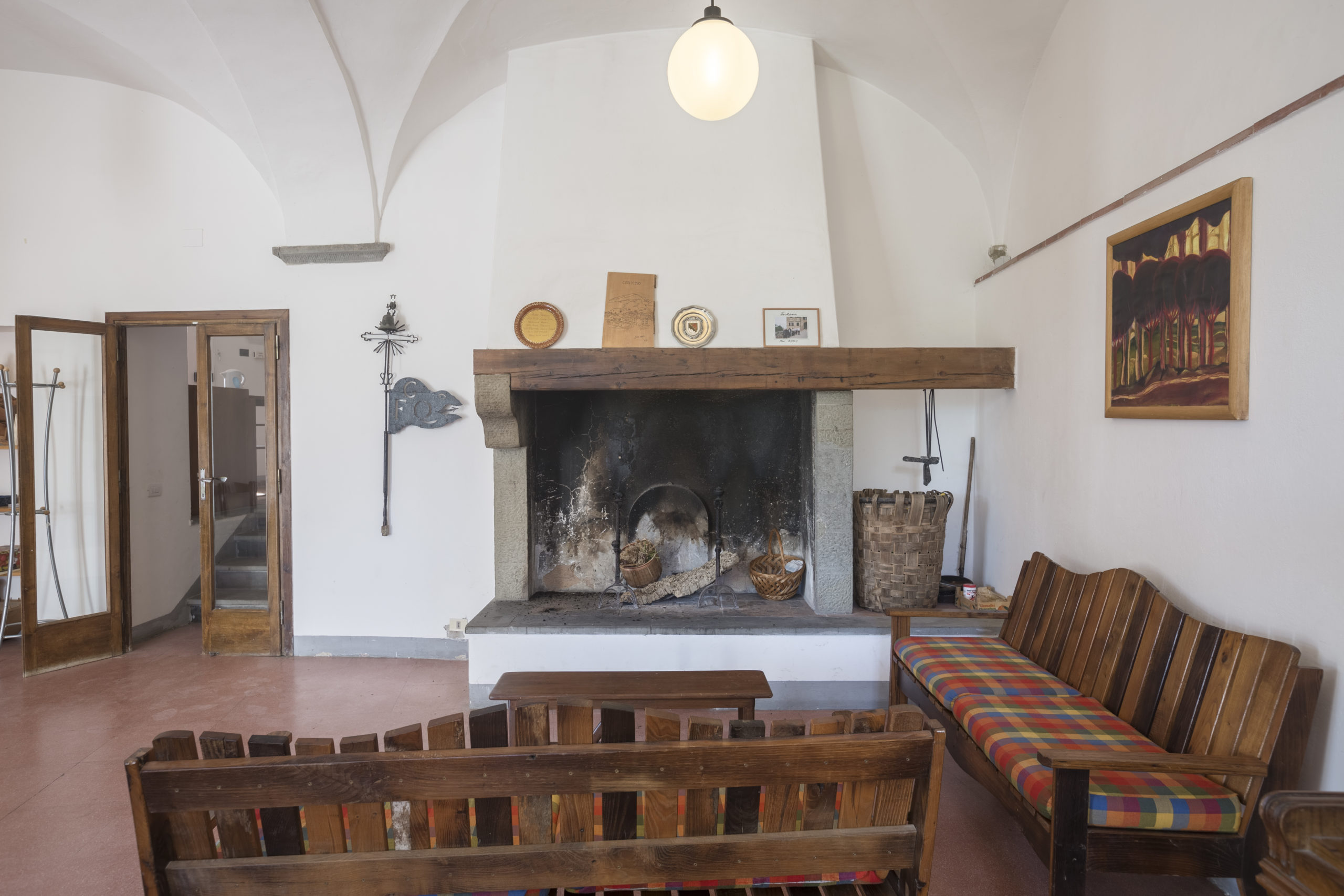 Interno della Sala della Stufa con momento conviviale davanti al fuoco, ideale per workshop e lettura